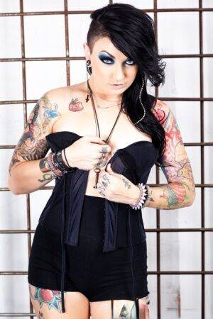 Tattooed girl Draven Star gets naked in heels inside a steel cage on nudepicso.com