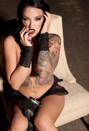 Tattooed girl Emily Parker takes off a gas mask and black bra outside at night on nudepicso.com