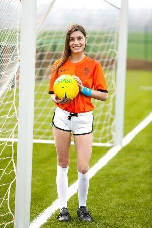 Lilly P is undressing her soccer uniform while on the field with a ball on nudepicso.com
