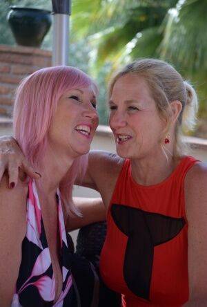 Middle-aged lesbians Melody & Molly MILF play with each others tits on a patio on nudepicso.com