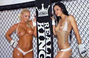 Busty lesbian babes stripping and posing in the wrestling cage on nudepicso.com