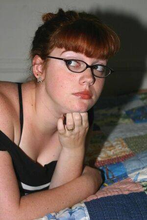 Chubby nerd with red hair takes off her glasses after uncupping big naturals on nudepicso.com