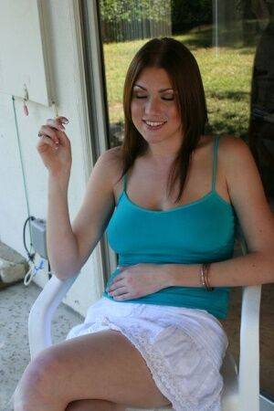 Barefoot chick Victoria Vonn smokes on the patio in a skirt and tank top on nudepicso.com