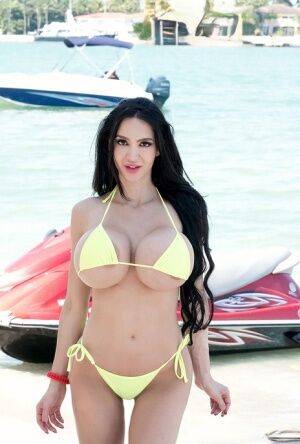 Hot curvy Amy Anderssen flaunts enormously round big tits on her jet ski on nudepicso.com