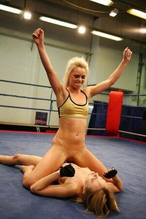 Pretty lesbians gasping and stripping each other in the wrestling ring on nudepicso.com