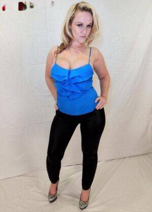 Blonde amateur Dee Siren displays her cleavage while wearing black leggings on nudepicso.com