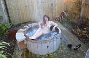 Amateur lady Barby Slut gets totally nude before getting in an outdoor hot tub on nudepicso.com