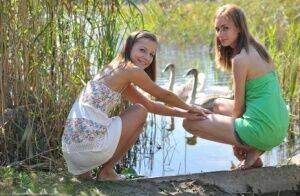 Young lesbians Nastya & Ashly get naked on a dock in the reeds on nudepicso.com