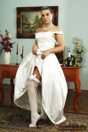 Fuckable bride in white stockings gets rid of her dress and lingerie on nudepicso.com