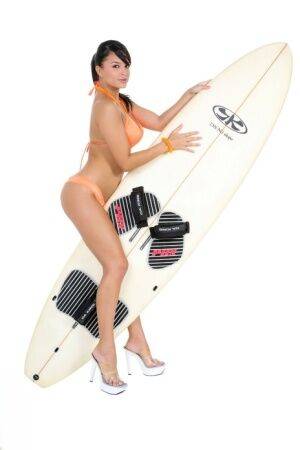 Sexy surfer girl Sarah peels off her bikini to model naked on her board on nudepicso.com