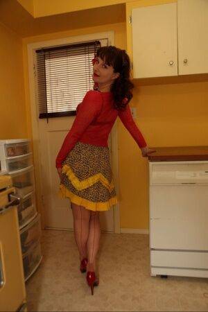 Older housewife Dirty Angie poses in retro lingerie and nylons in kitchen on nudepicso.com