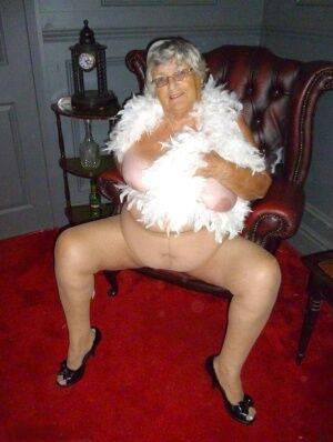 Fat nan Grandma Libby wears a feather boa while baring her saggy tits and butt on nudepicso.com