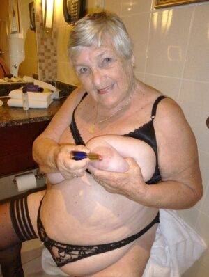 Fat nan Grandma Libby removes a bathrobe to pose nude in a cupless bra on nudepicso.com