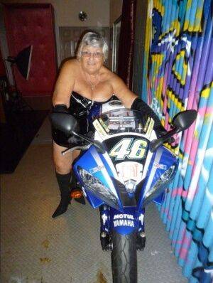 Old fatty Grandma Libby strips to black boots on top of a motorcycle on nudepicso.com