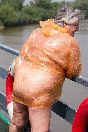Obese oma Grandma Libby doffs a see-through raincoat to get naked on a bridge on nudepicso.com