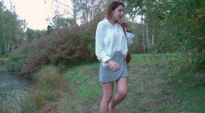 Brunette cutie squats to piss near the lake on nudepicso.com