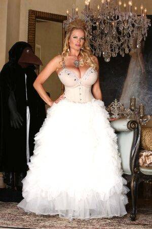 Blonde chick Kelly Madison releases her big tits from her white gown on nudepicso.com
