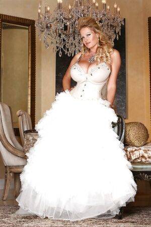 Kelly Madison is posing in a sexy wedding dress and white stockings on nudepicso.com