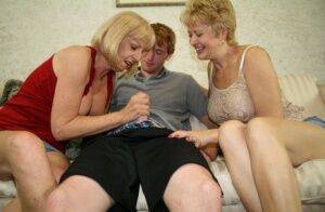 Two blonde grannies share a horny student's hard white dick on the sofa on nudepicso.com