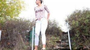 Mature Bianca pulls down her white pants to take a steaming pee outside on nudepicso.com