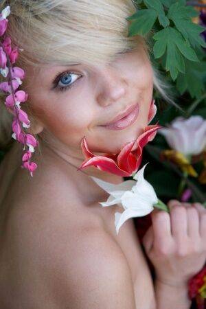 Cute young blonde Iveta poses in the nude while in a garden on nudepicso.com