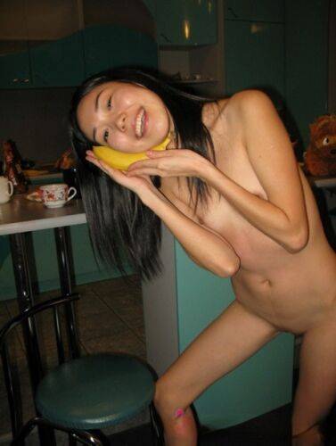 Skinny Filipina teen Nicoline Yiki fools around with a banana while bare naked on nudepicso.com