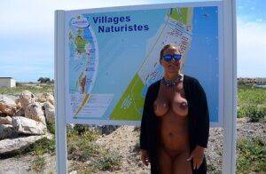 Mature fatty Chrissy walks by the sea with her round big tits bared on nudepicso.com