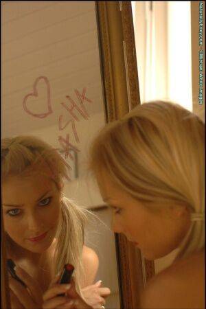 Gorgeous blonde Natasha Marley goes topless in front of a mirror on nudepicso.com